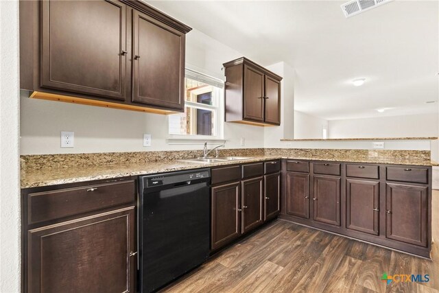 kitchen with light stone counters, sink, dark wood-type flooring, and dishwasher