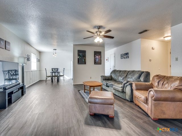 living room with hardwood / wood-style flooring, a textured ceiling, and ceiling fan