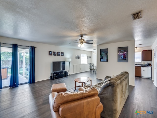 living room featuring a textured ceiling, dark hardwood / wood-style floors, and ceiling fan