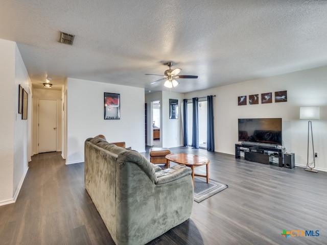 living room with dark hardwood / wood-style flooring, a textured ceiling, and ceiling fan