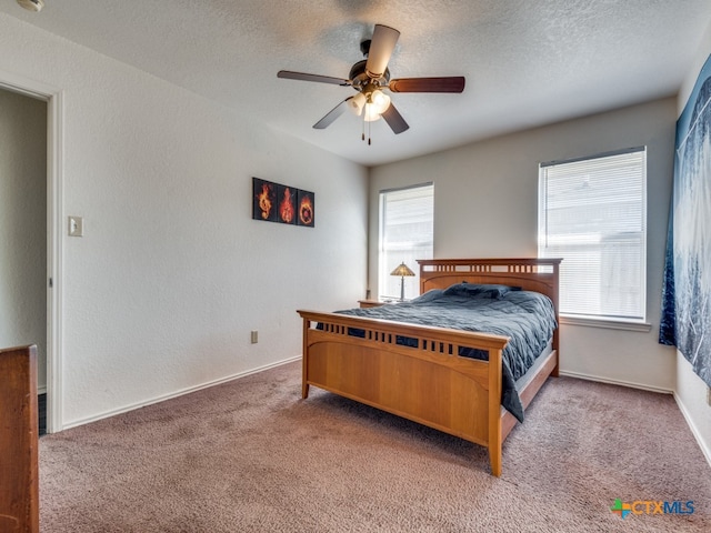 bedroom with a textured ceiling, carpet flooring, and ceiling fan