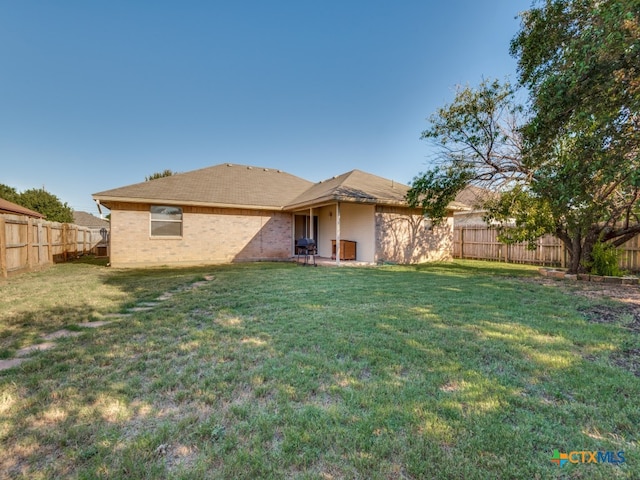 rear view of property with a lawn