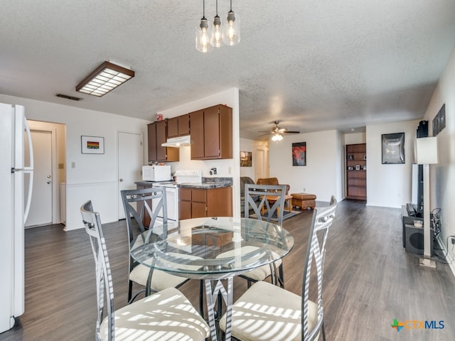 dining room featuring ceiling fan, dark hardwood / wood-style floors, and a textured ceiling