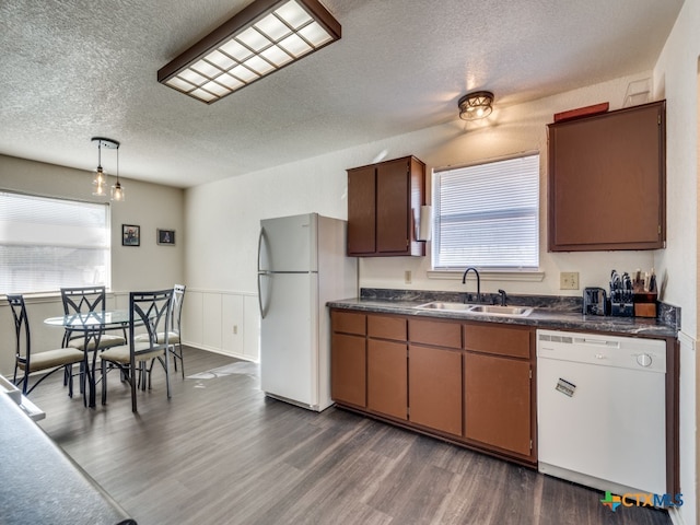 kitchen featuring hanging light fixtures, a textured ceiling, sink, dark hardwood / wood-style floors, and white appliances