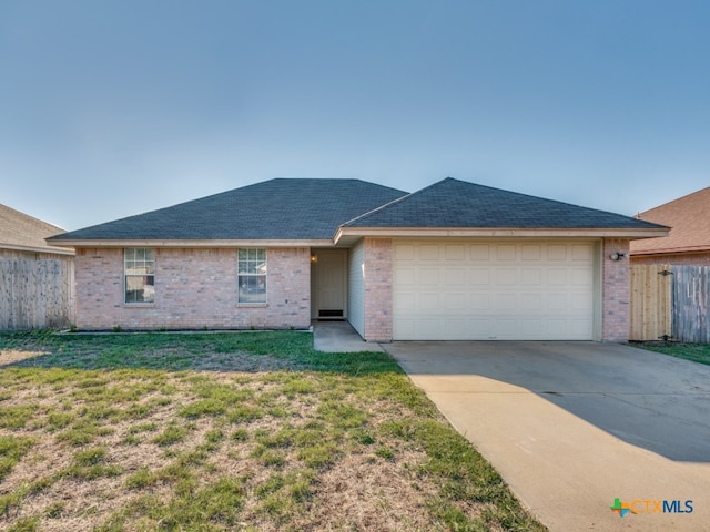 ranch-style home featuring a garage and a front yard