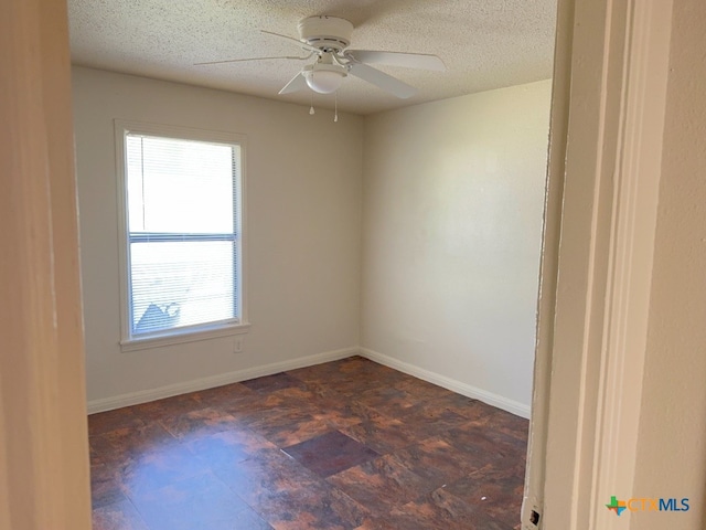 empty room with ceiling fan and a textured ceiling