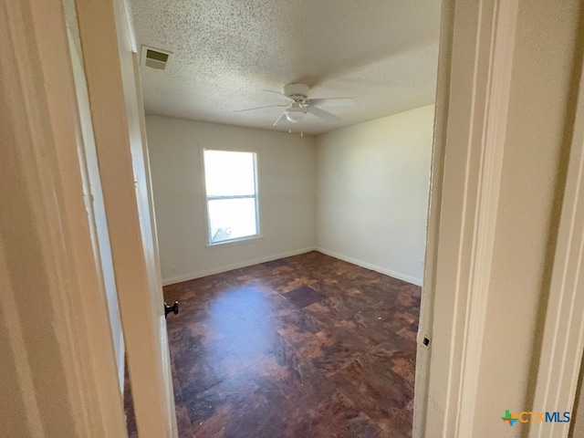 empty room featuring a textured ceiling and ceiling fan