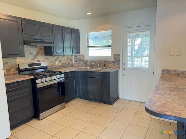 kitchen with light tile patterned flooring, backsplash, sink, and gas range