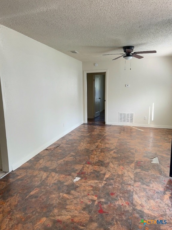 empty room featuring a textured ceiling and ceiling fan