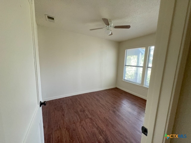 unfurnished room featuring ceiling fan, a textured ceiling, and dark hardwood / wood-style flooring