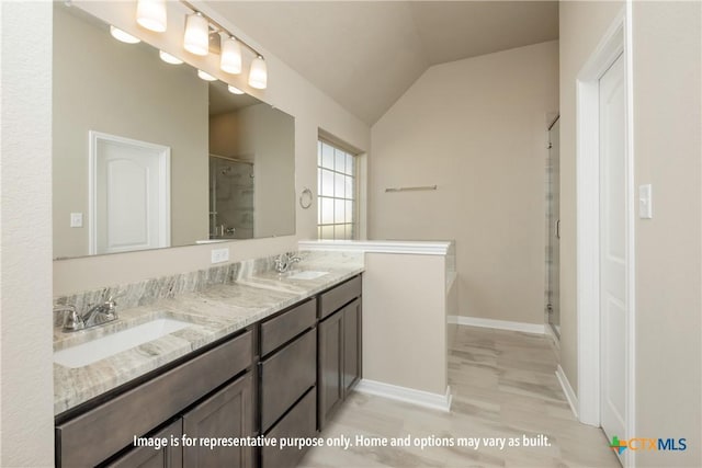 bathroom featuring vanity, vaulted ceiling, and a shower with shower door