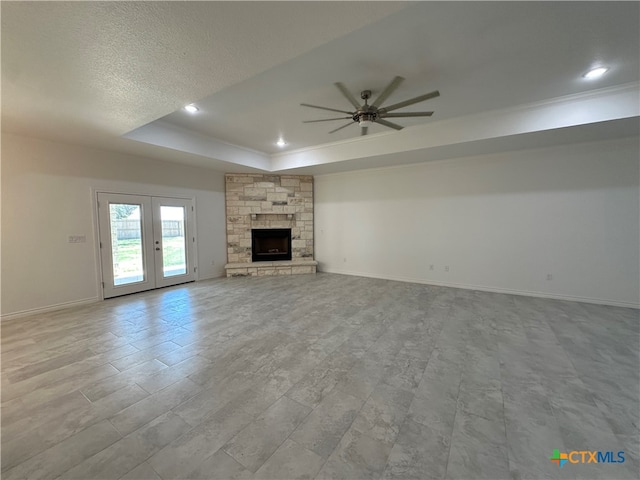 unfurnished living room featuring french doors, light wood-type flooring, a fireplace, and ceiling fan