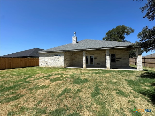 back of house featuring a lawn and a patio