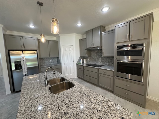 kitchen with appliances with stainless steel finishes, decorative light fixtures, gray cabinets, decorative backsplash, and sink