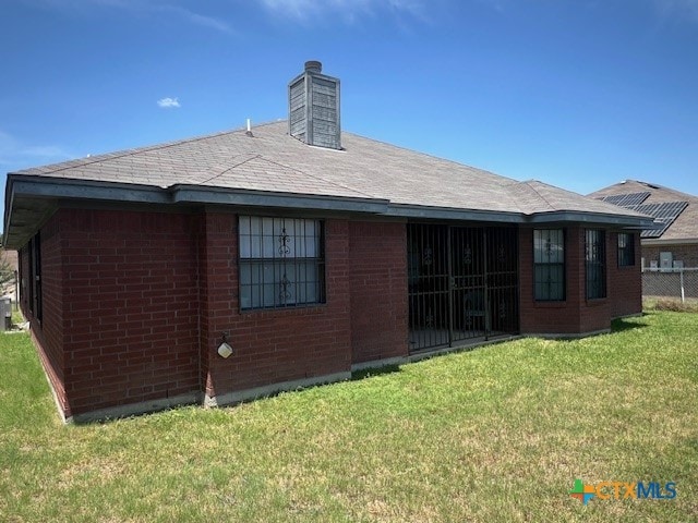 rear view of property with a lawn