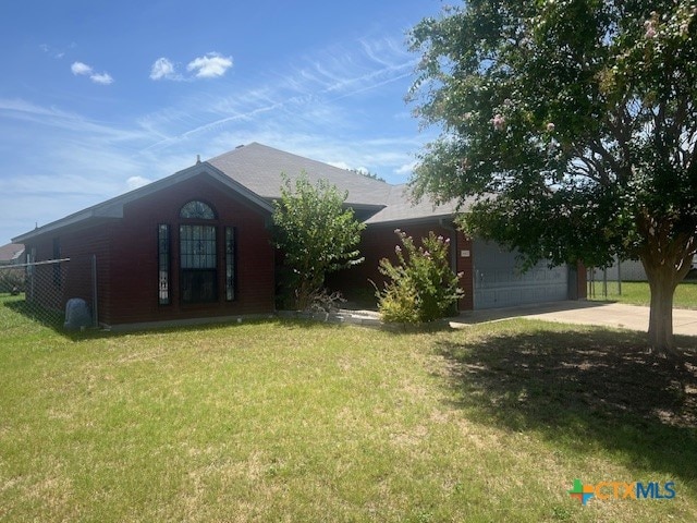 view of front of house with a garage and a front lawn