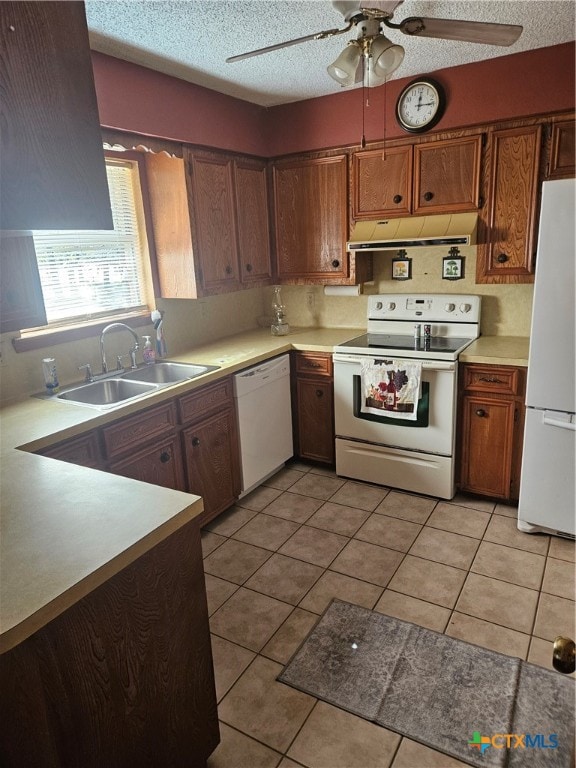 kitchen featuring light tile patterned floors, white appliances, and a textured ceiling