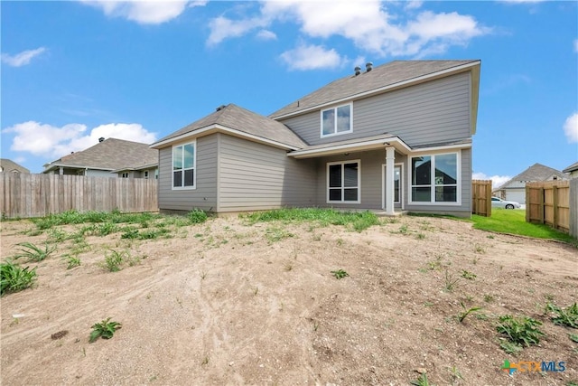 rear view of house featuring fence