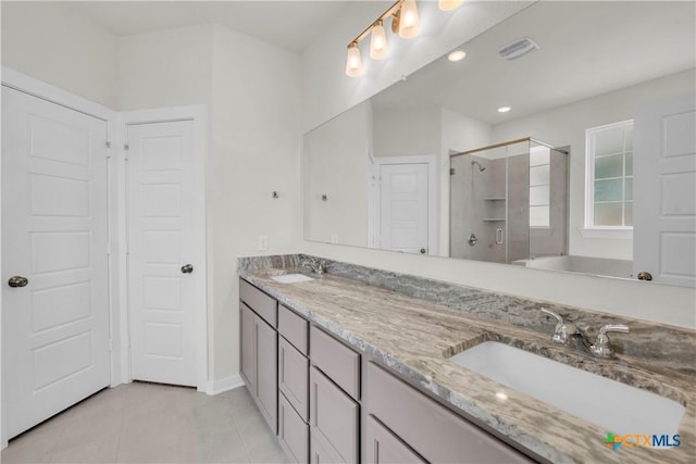 full bath featuring tile patterned flooring, a sink, double vanity, and a stall shower