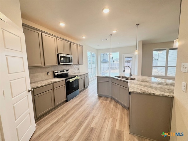 kitchen featuring sink, black appliances, light stone counters, hanging light fixtures, and dark wood-type flooring