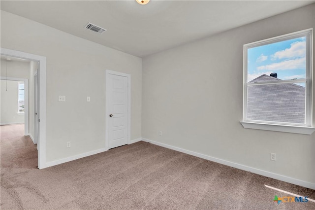 empty room featuring baseboards, visible vents, and carpet