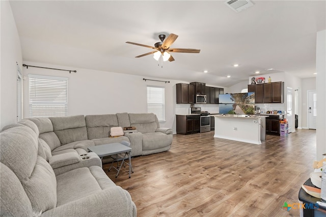 living room with light wood-type flooring and ceiling fan