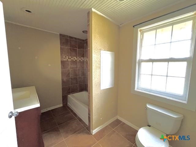 full bathroom with tile patterned flooring, vanity, tiled shower / bath combo, and toilet