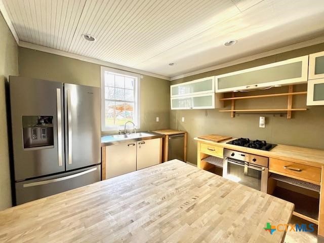 kitchen with appliances with stainless steel finishes, butcher block countertops, sink, ornamental molding, and wood ceiling