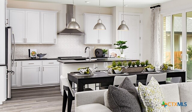 236 Torchwood Dr, Marble Falls, TX 78654 - kitchen with sink, white cabinetry, stainless steel fridge, decorative backsplash, and wall chimney range hood