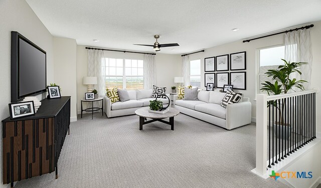 living room with ceiling fan, light colored carpet, and a textured ceiling