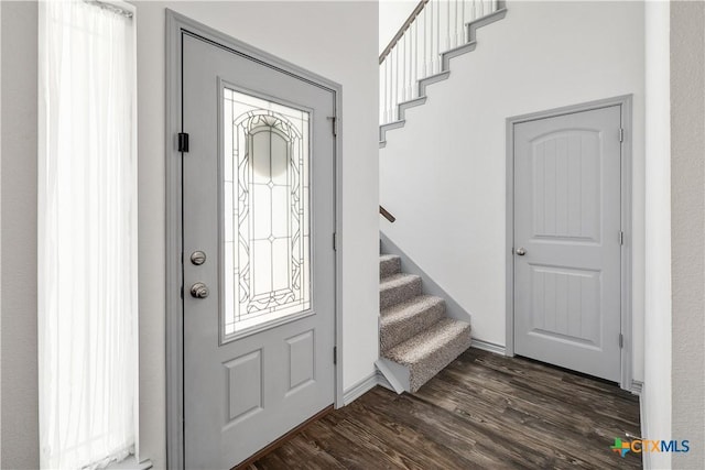 foyer featuring dark wood-style floors and stairway