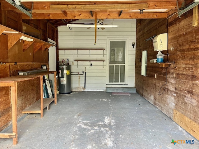 garage with water heater and wooden walls