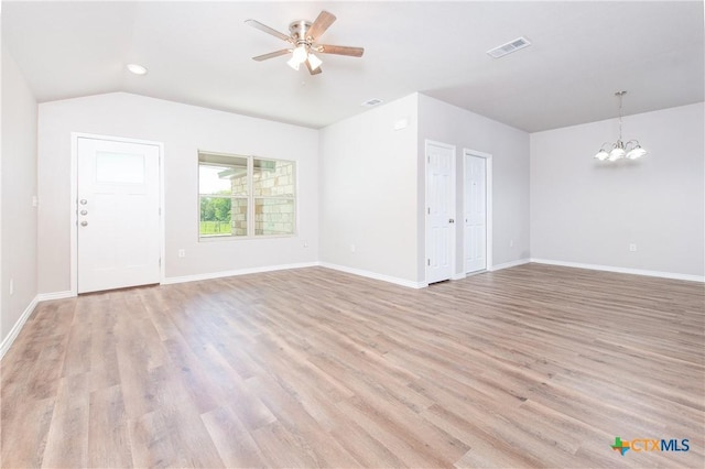 unfurnished living room featuring ceiling fan with notable chandelier, light wood-type flooring, and vaulted ceiling