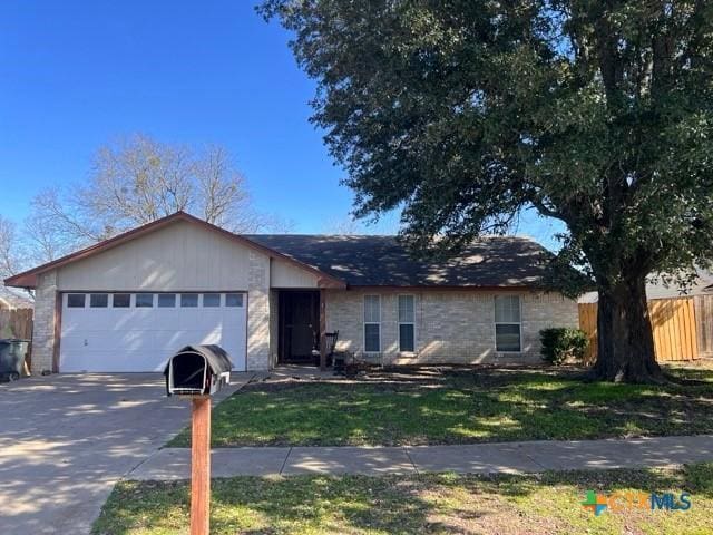 ranch-style home with a garage and a front lawn