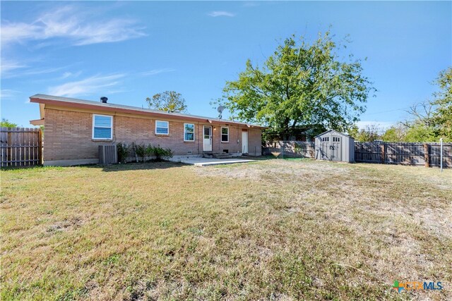 back of property featuring central AC, a patio area, a yard, and a shed