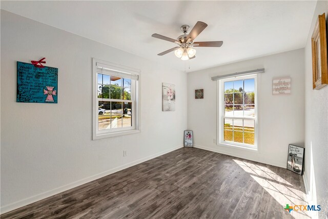 empty room with dark hardwood / wood-style floors and ceiling fan