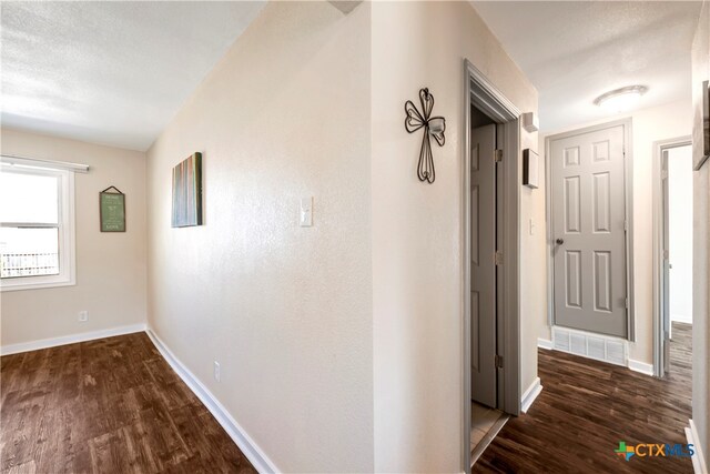 corridor with dark hardwood / wood-style flooring