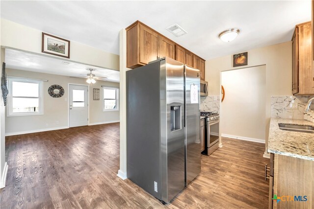 kitchen with appliances with stainless steel finishes, backsplash, dark hardwood / wood-style flooring, and sink