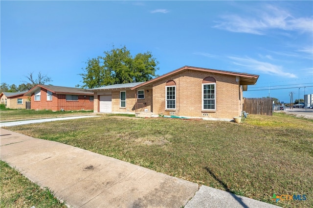 ranch-style home featuring a garage and a front lawn