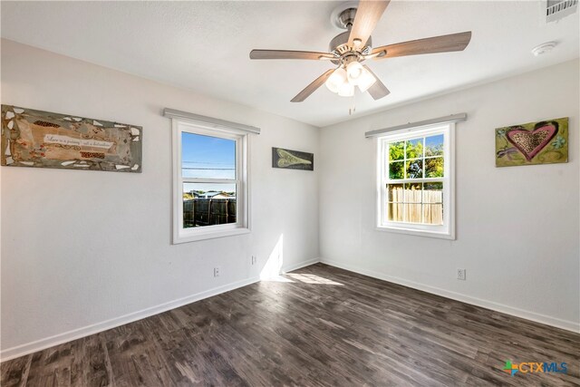 unfurnished room with dark hardwood / wood-style flooring and ceiling fan