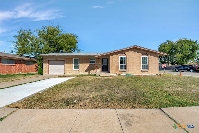 ranch-style home featuring a garage and a front lawn