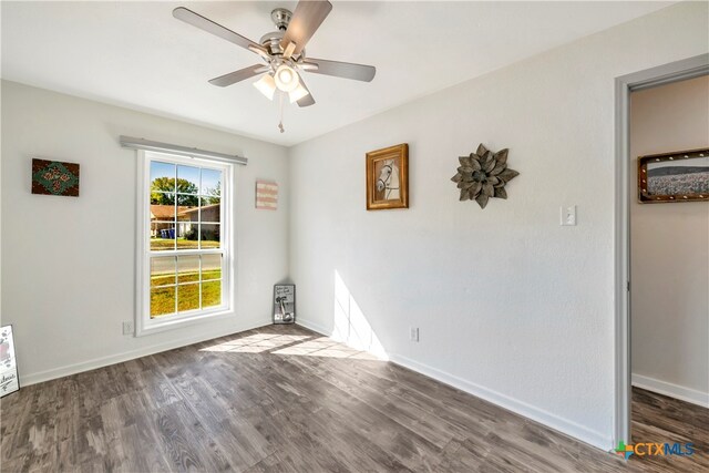 spare room with dark hardwood / wood-style floors and ceiling fan