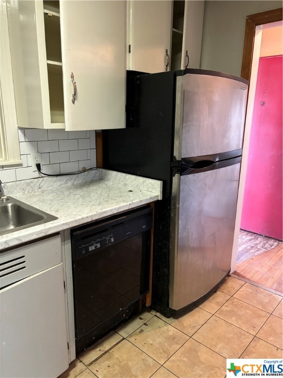 kitchen featuring dishwasher, light hardwood / wood-style flooring, stainless steel refrigerator, and white cabinets