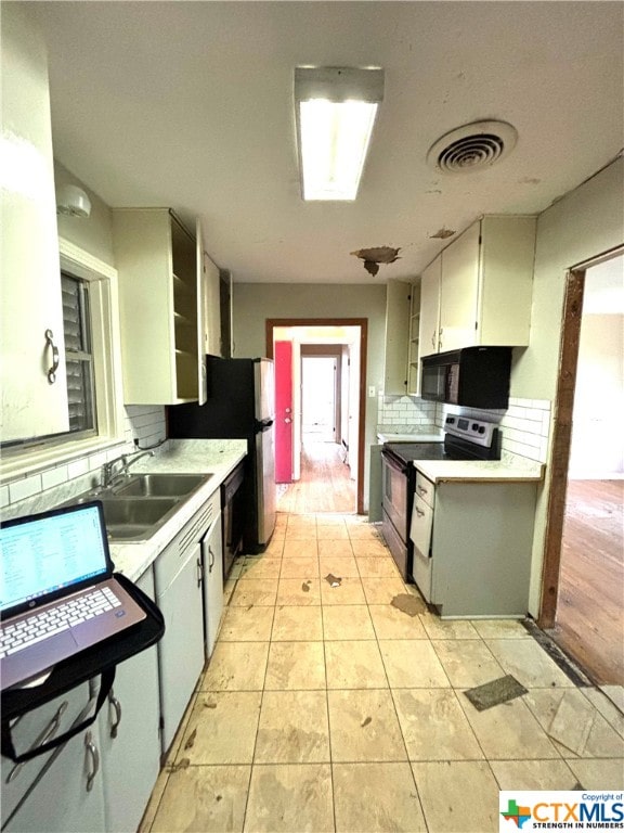 kitchen featuring light hardwood / wood-style flooring, sink, black appliances, and tasteful backsplash