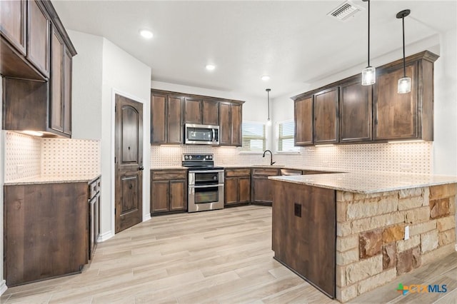 kitchen with pendant lighting, stainless steel appliances, and dark brown cabinets