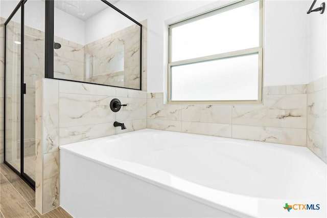 bathroom featuring plus walk in shower and hardwood / wood-style floors