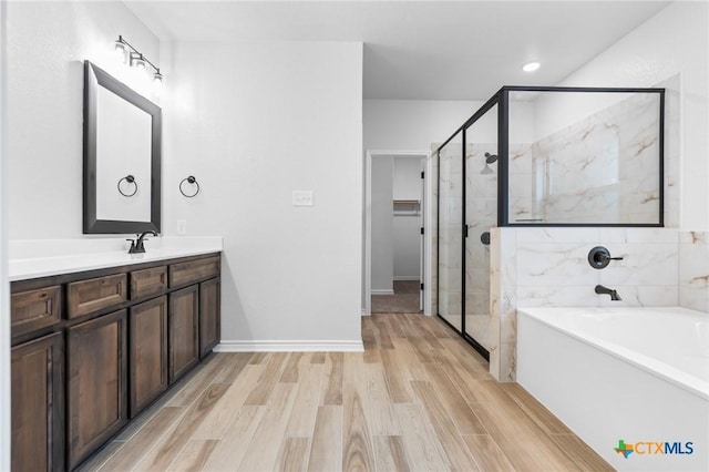 bathroom with vanity, wood-type flooring, and plus walk in shower