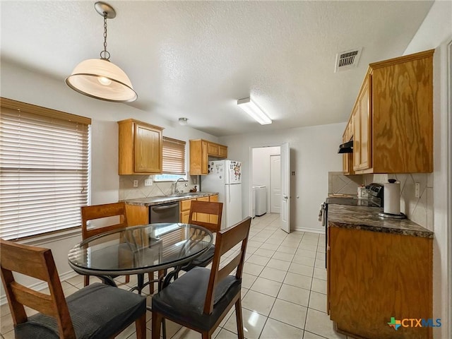 408 Rowdy Dr, Killeen, TX 76542 - dining area with light tile patterned floors, a textured ceiling, and separate washer and dryer