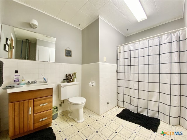 bathroom featuring toilet, walk in shower, tile walls, ornamental molding, and vanity