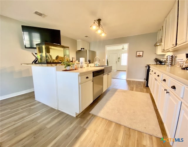 kitchen with sink, white cabinets, stainless steel appliances, and light wood-type flooring